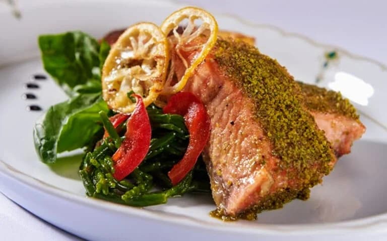 Crusted salmon fillet plated with vegetables